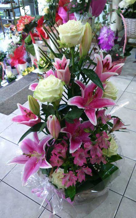 A romantic basket with white roses, oriental lilies and astromeries