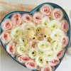 Arrangement with 15 roses and 13 rosy white roses with small honey